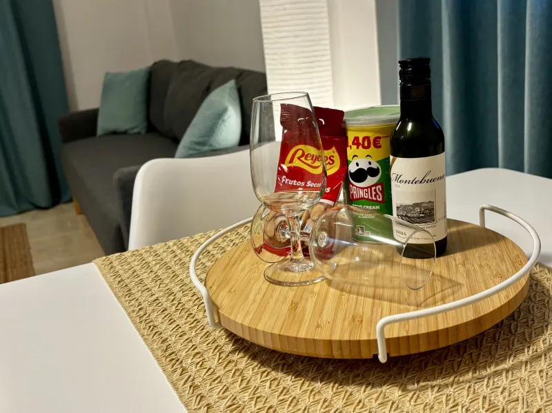 Detalle de bienvenida: vino, aperitivos y bandeja sobre la mesa