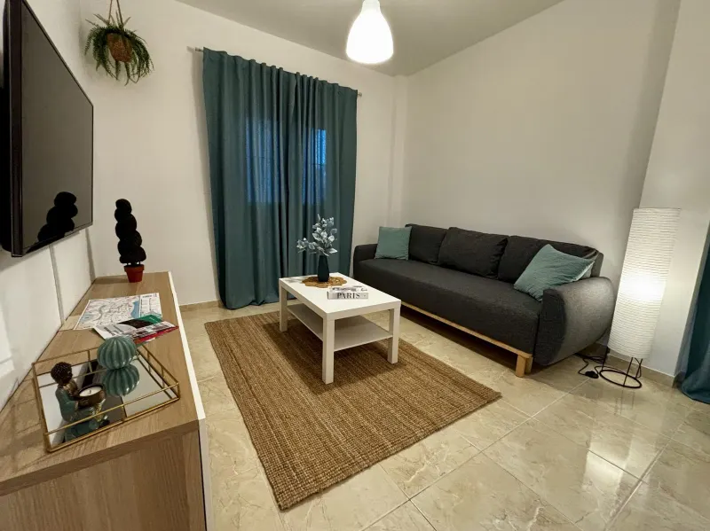 Salón luminoso con sofá gris y cortinas azules